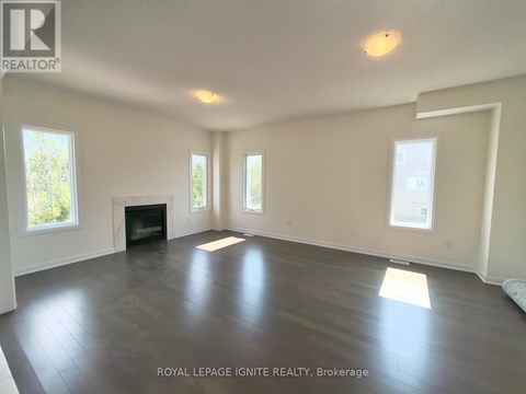 A spacious room with a fireplace and large windows.