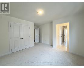 A white bedroom with a door and a window.
