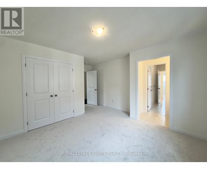 A white bedroom with a door and a window.