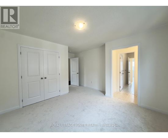 A white bedroom with a door and a window.