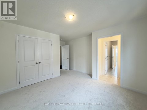 A white bedroom with a door and a window.