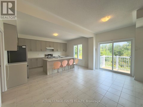 A spacious kitchen and dining area with a television and sliding glass doors.