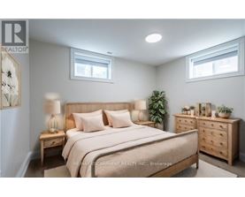 A bedroom with a large bed, nightstands, and a dresser.