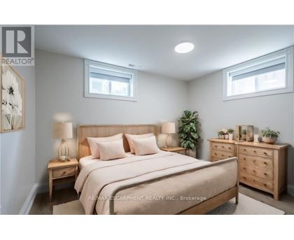 A bedroom with a large bed, nightstands, and a dresser.