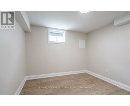 A room with a window and wooden flooring.