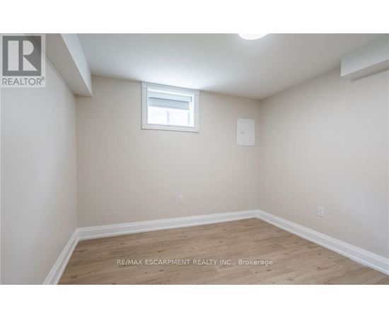 A room with a window and wooden flooring.