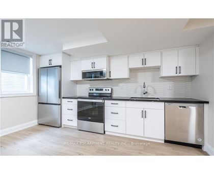 A kitchen with white cabinets and stainless steel appliances.