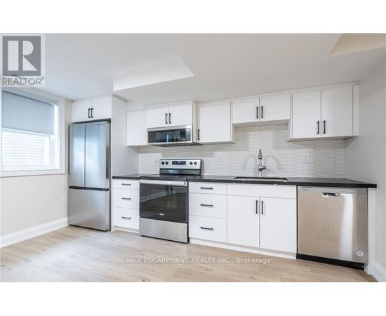 A kitchen with white cabinets and stainless steel appliances.