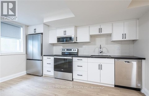 A kitchen with white cabinets and stainless steel appliances.