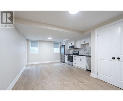 A well-lit, spacious kitchen with white cabinets and a microwave above the stove.