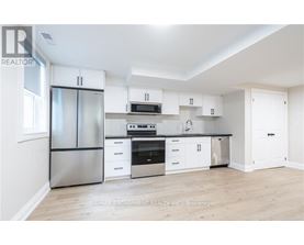 A white kitchen with a refrigerator, oven, microwave, and cabinets.