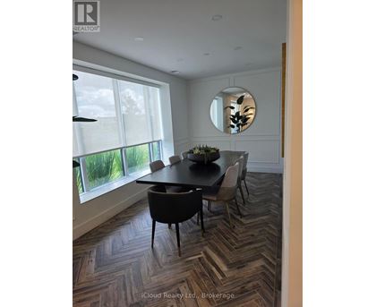 A dining room with a round table and chairs.