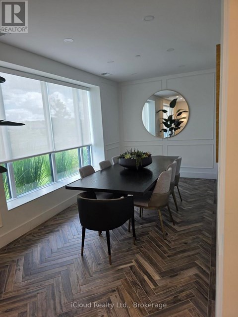 A dining room with a round table and chairs.