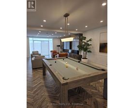 A pool table in a room with a light brown herringbone patterned floor.