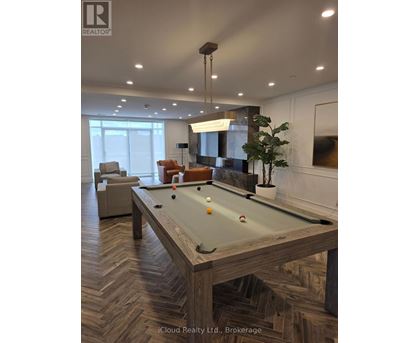 A pool table in a room with a light brown herringbone patterned floor.
