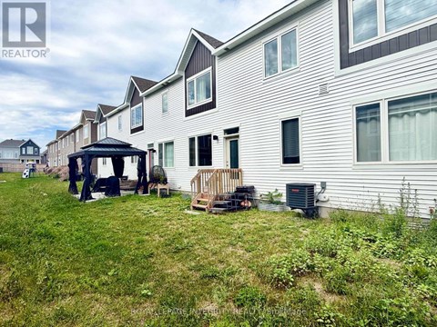 A realtor photo of a house with a gazebo and a deck.