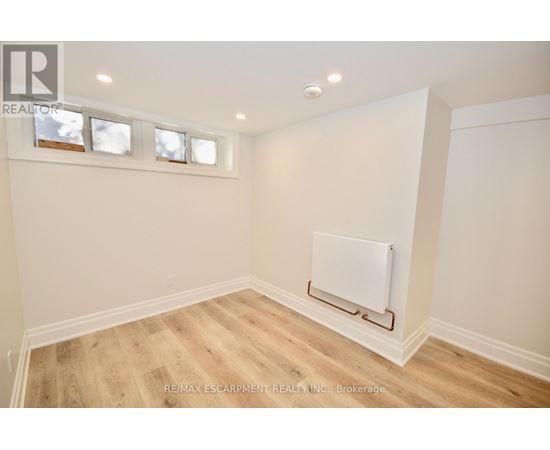 A room with a white wall and a white radiator on the wall.