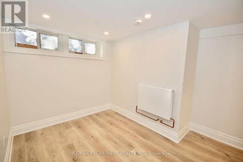 A room with a white wall and a white radiator on the wall.
