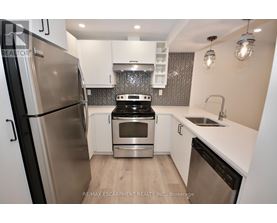 A modern kitchen with a stainless steel refrigerator and a black dishwasher.