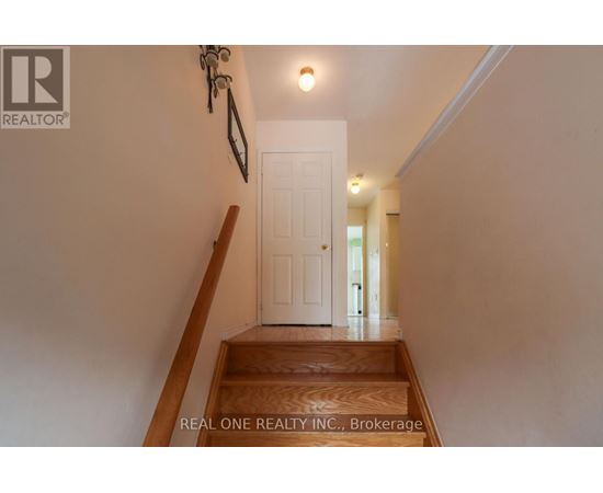 A hallway with a white door and a wooden staircase.