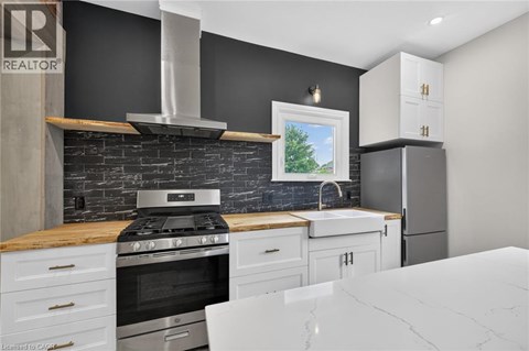 A modern kitchen with a black wall and a stove top oven.