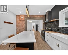A modern kitchen with a large island and a brick wall.