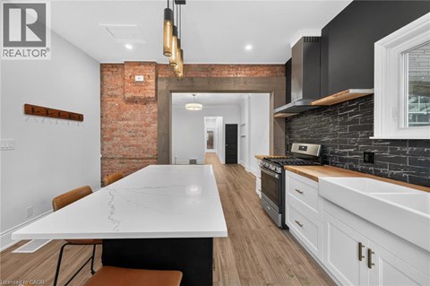 A modern kitchen with a large island and a brick wall.