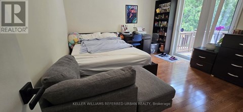 A bedroom with a bed, dresser and chair.