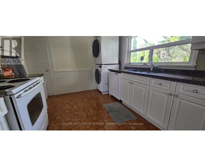A kitchen with a white oven and a tiled floor.