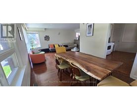 A dining room with a wooden table and chairs.