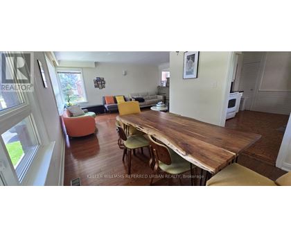 A dining room with a wooden table and chairs.