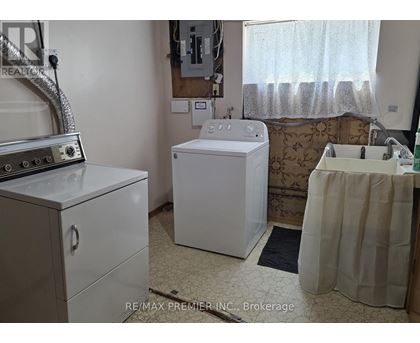 A white washing machine sits in a small laundry room.
