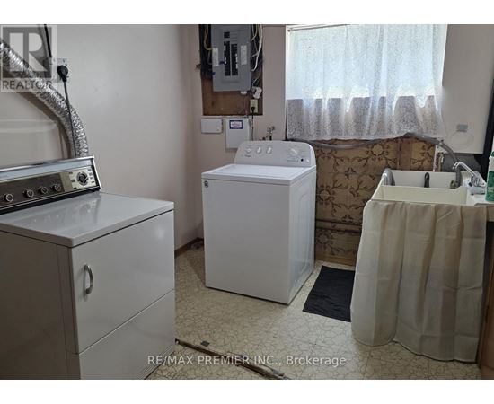 A white washing machine sits in a small laundry room.