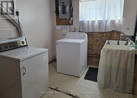 A white washing machine sits in a small laundry room.