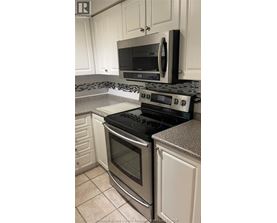 A kitchen with a black stove top oven and microwave above it.
