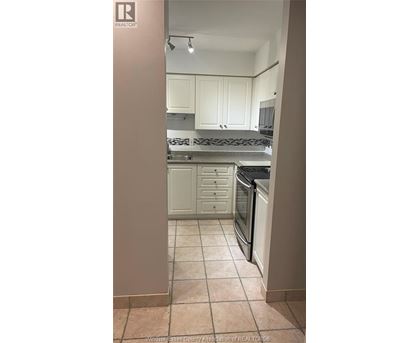 A kitchen with white cabinets and a tile floor.