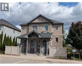 A house with a grey front yard and a sign that says REALTOR.