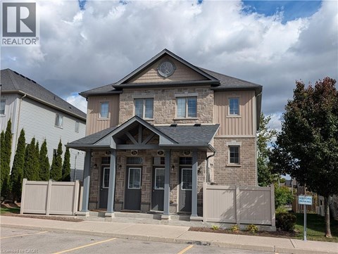 A house with a grey front yard and a sign that says REALTOR.