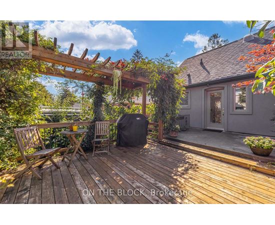 A wooden deck with a table and chairs and a house in the background.