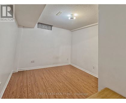 A room with wooden flooring and white walls.
