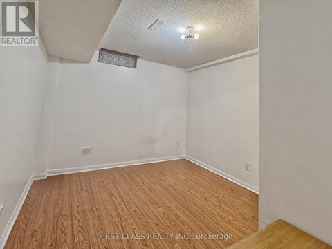 A room with wooden flooring and white walls.