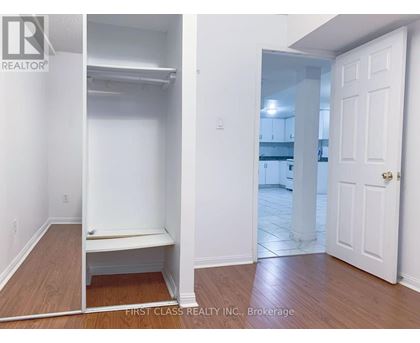 A bedroom with a white door and a white bench in the corner.