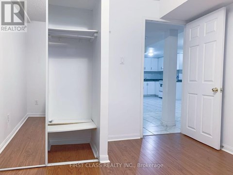 A bedroom with a white door and a white bench in the corner.