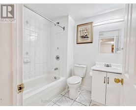 A white bathroom with a toilet, sink, and bathtub.