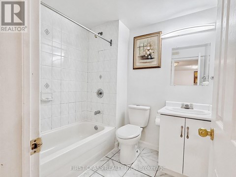 A white bathroom with a toilet, sink, and bathtub.