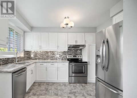 A kitchen with white cabinets and a tile backsplash.