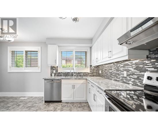 A kitchen with white cabinets and a black stove top oven.