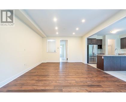 A spacious living room with wooden floors and white walls.