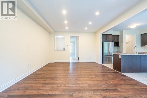 A spacious living room with wooden floors and white walls.