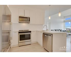 A modern kitchen with stainless steel appliances and white cabinets.